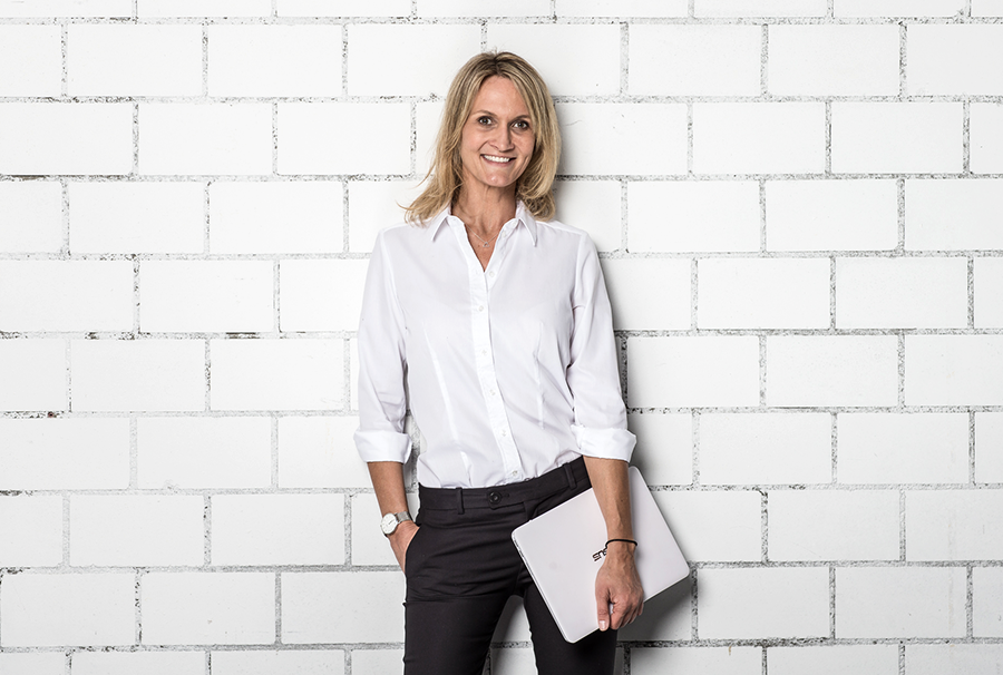 Bewerbungsfoto Luzern vor hellem Backsteinhintergrund