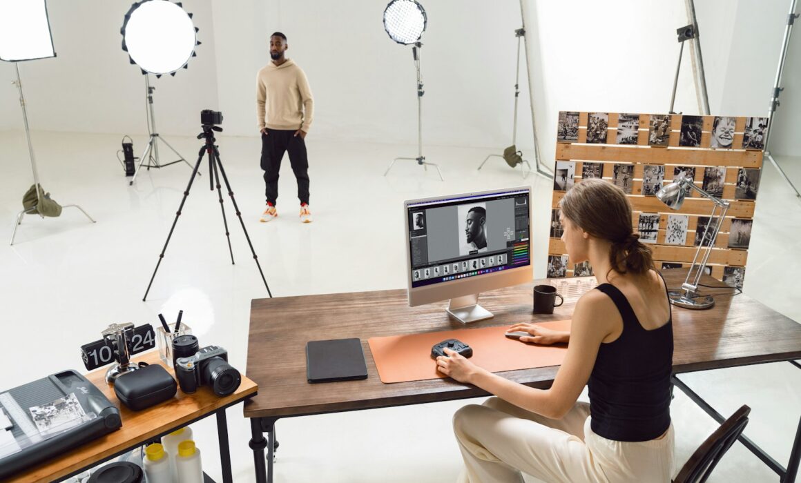 Fotografin bearbeitet ein Bewerbungsfoto am Bildschirm in einem Fotostudio