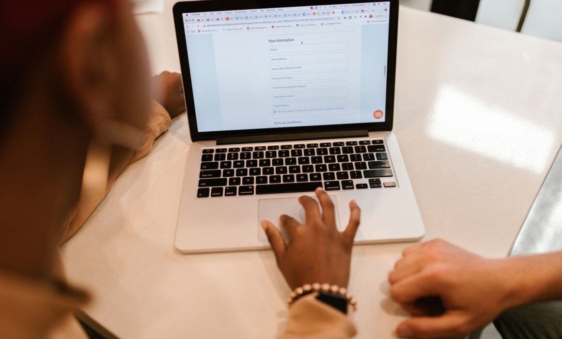 Hände tippen auf einem Laptop – Online-Bewerbung mit digitalem Bewerbungsfoto